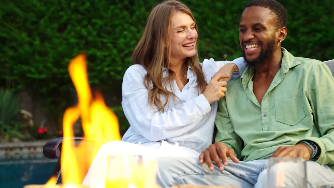 People enjoying an outdoor fire table at dusk